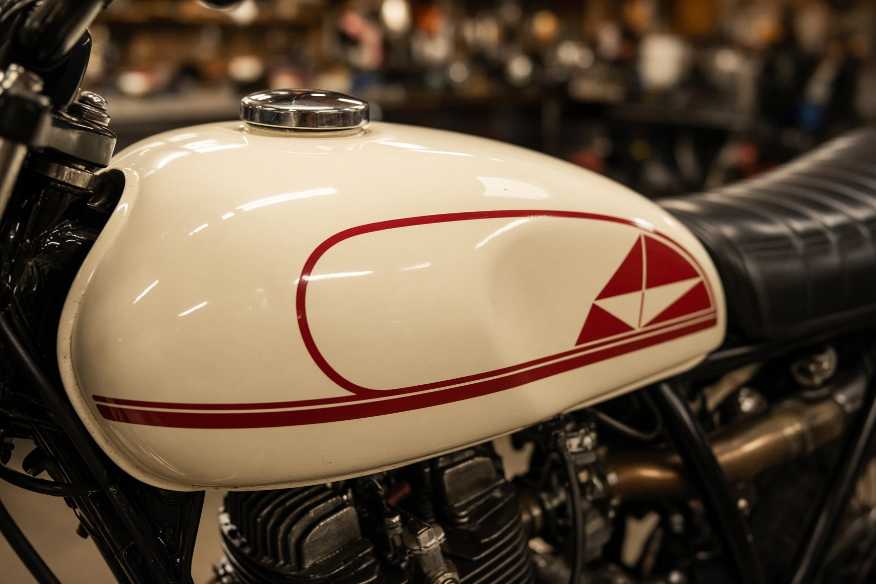 Vintage motorcycle tank with cream paint and red pinstripe vinyl